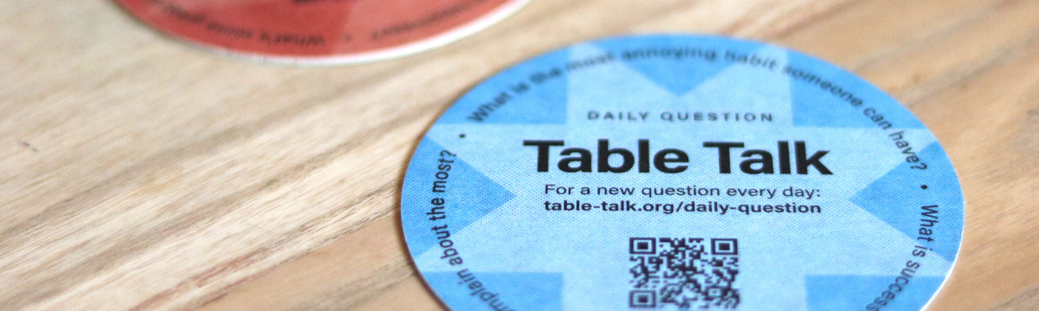 Table Talk coaster with QR code on a wooden surface